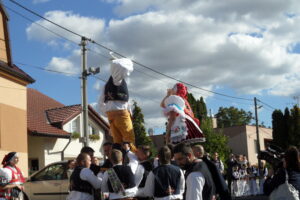 Popíjení a tancování v židlích nad průvodem.