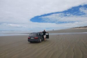 Working holiday Nový Zéland. S autem na 90 mile Beach na Severním ostrově.