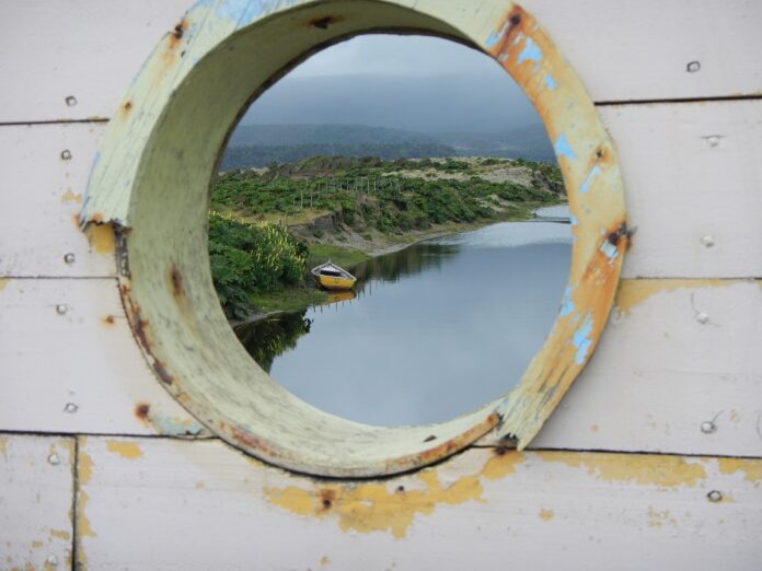 Loď v mostě s výhledem na řeku. Cucao, Chiloé, Chile